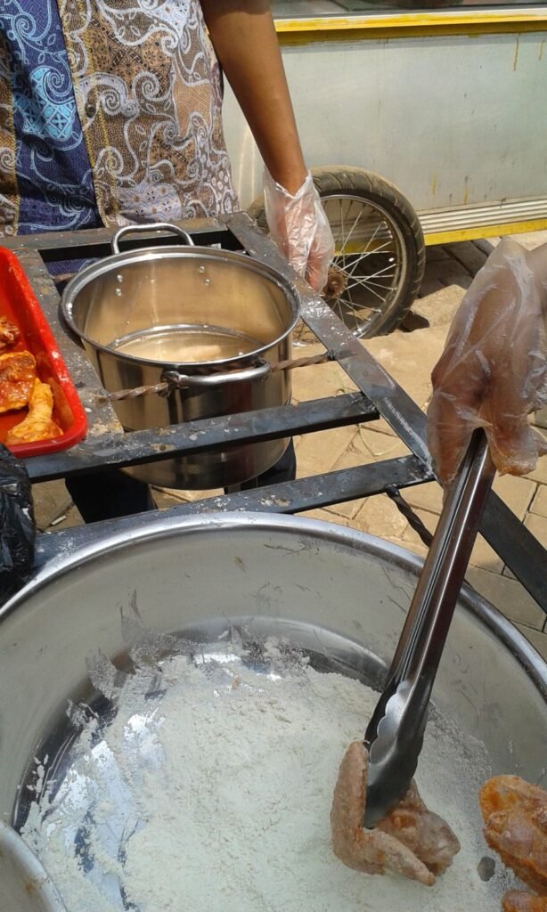 Membalur ayam dengan tepung ayam crispy sebelum digoreng