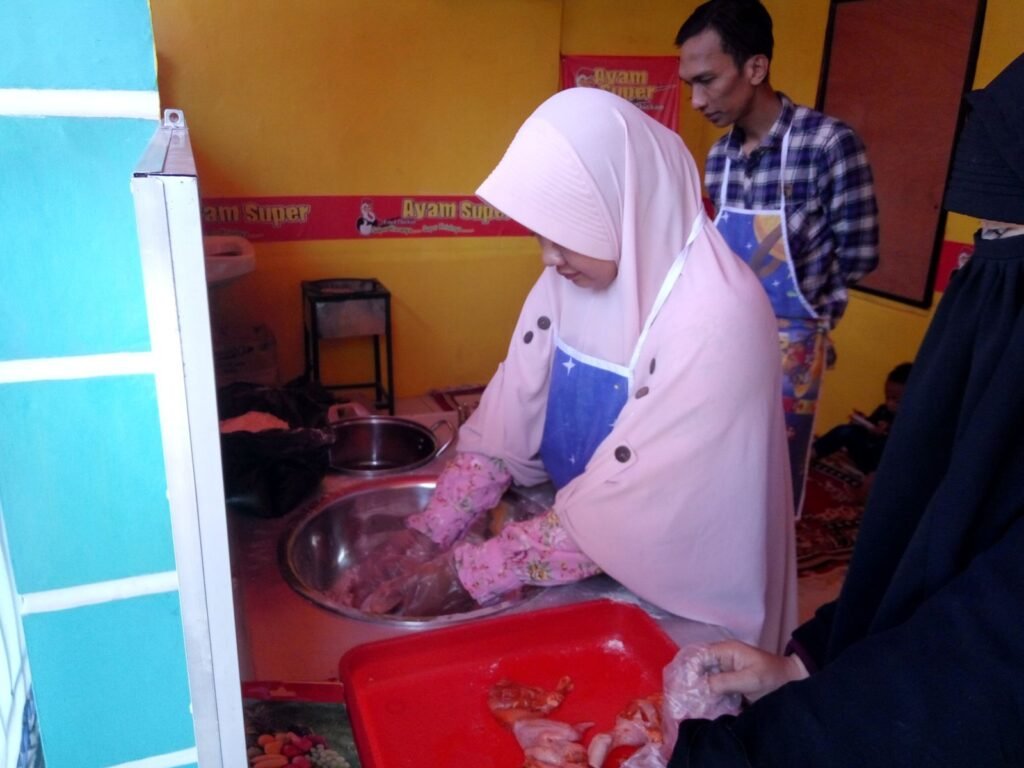 Mitra mengolah ayam dengan bumbu marinasi ayam